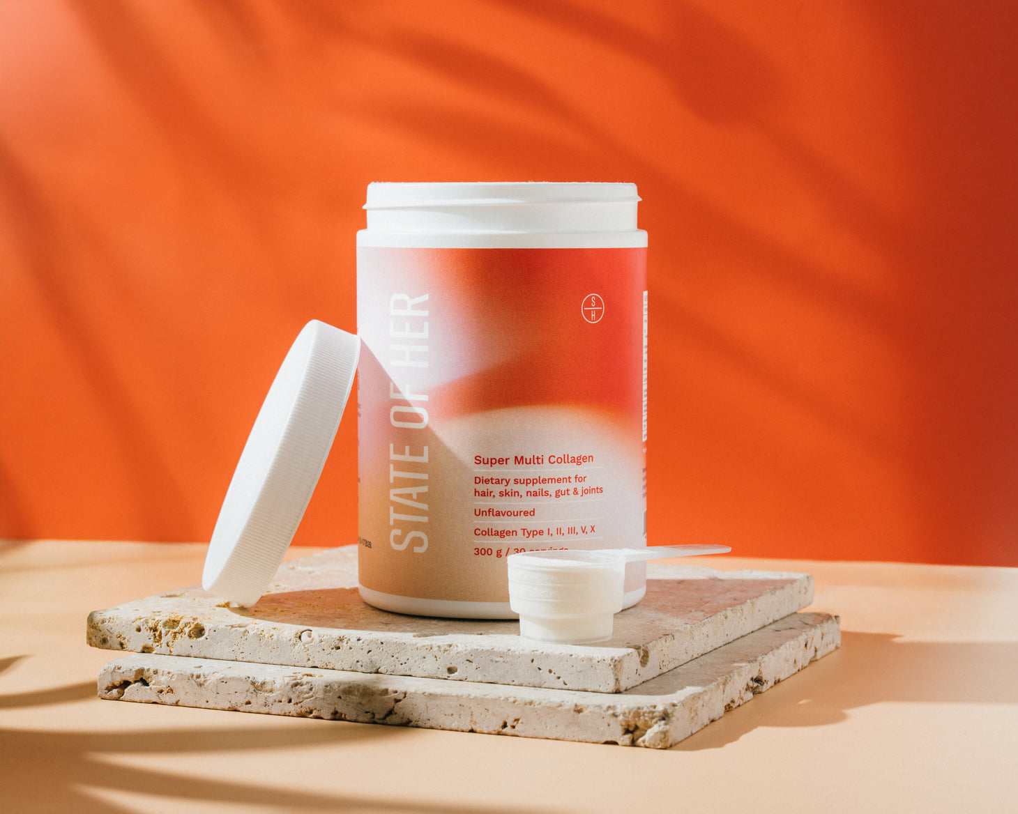 Supplement container labeled 'State of Well' on a wooden surface with an orange background